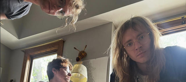 Band photo; two people lie on the floor staring up at the camera.
