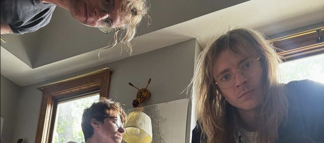 Band photo; two people lie on the floor staring up at the camera.